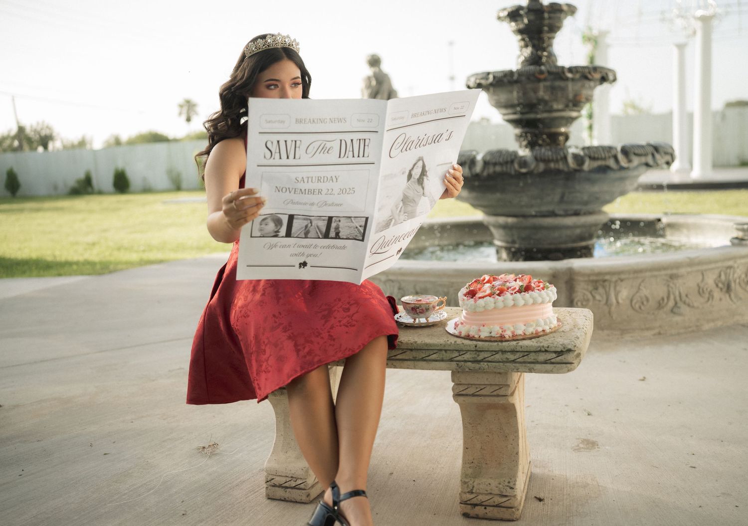 A celebratory photoshoot near a decorative stone fountain in an outdoor garden setting.