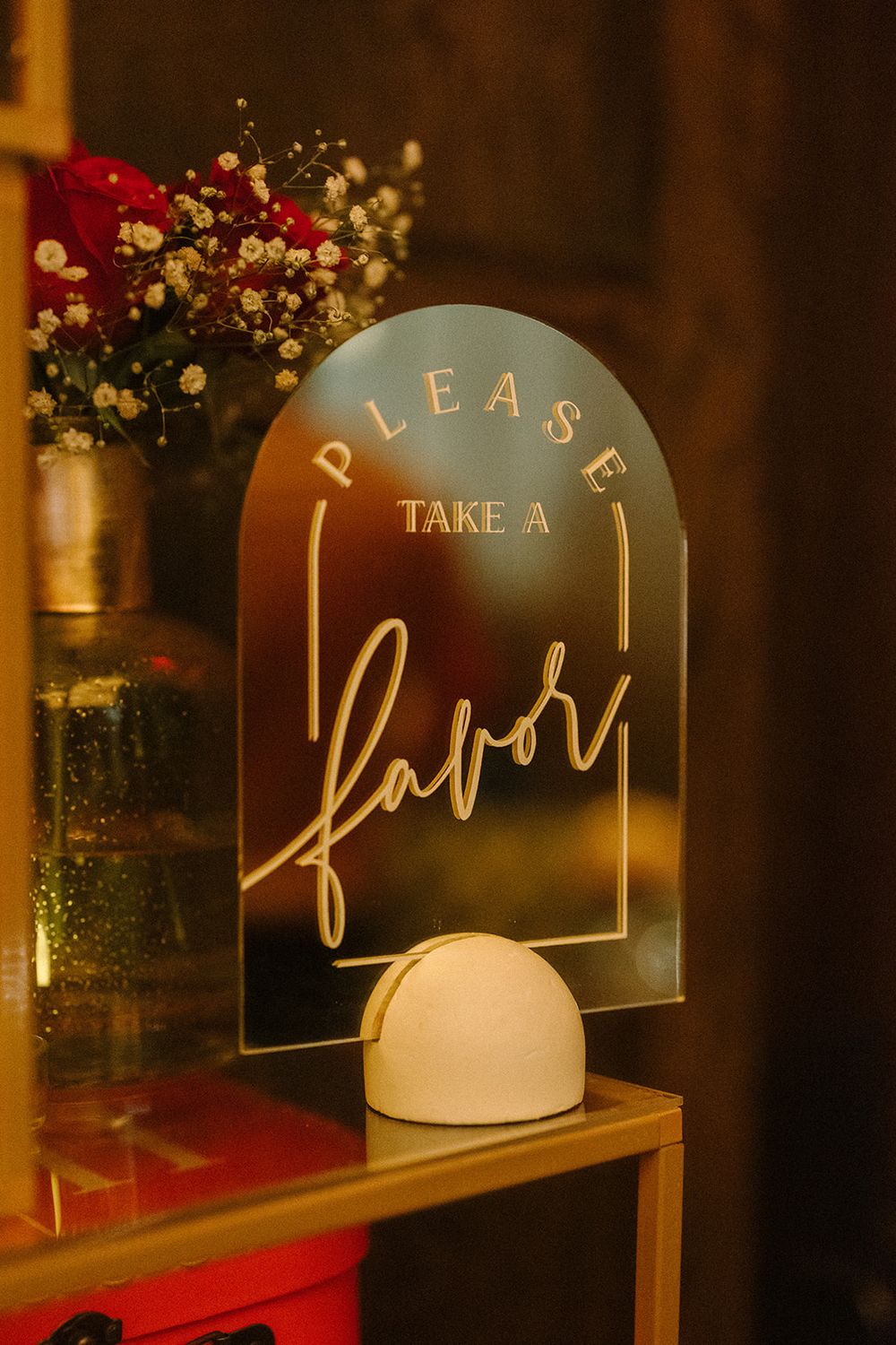 Illuminated decorative signs with gold lettering spell out 'TAKE A' and other text against a dark background with sparkly decor.