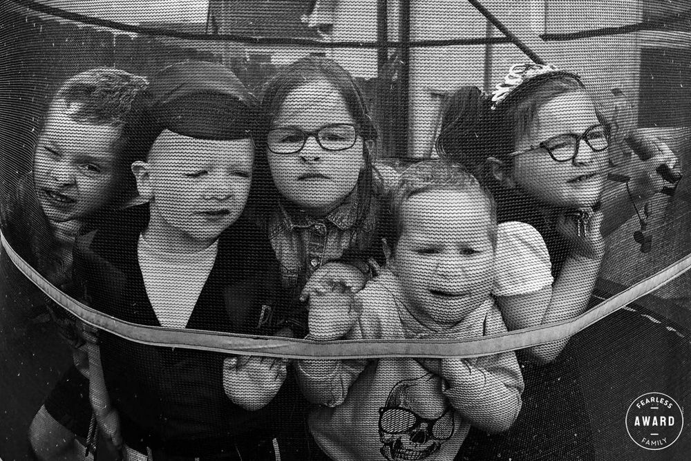 Black and white vintage photo of children looking through playground equipment.