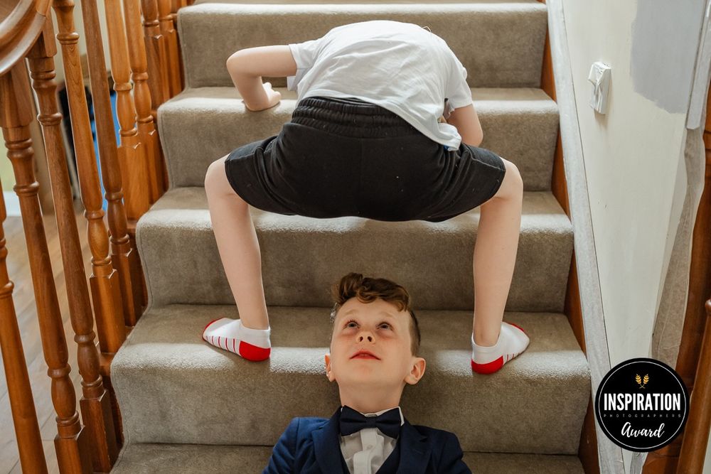 Creative perspective shot of children playing on carpeted stairs indoors.