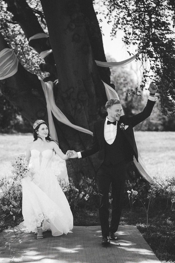 Black and white photos of newlyweds dancing together in an elegant outdoor garden setting.