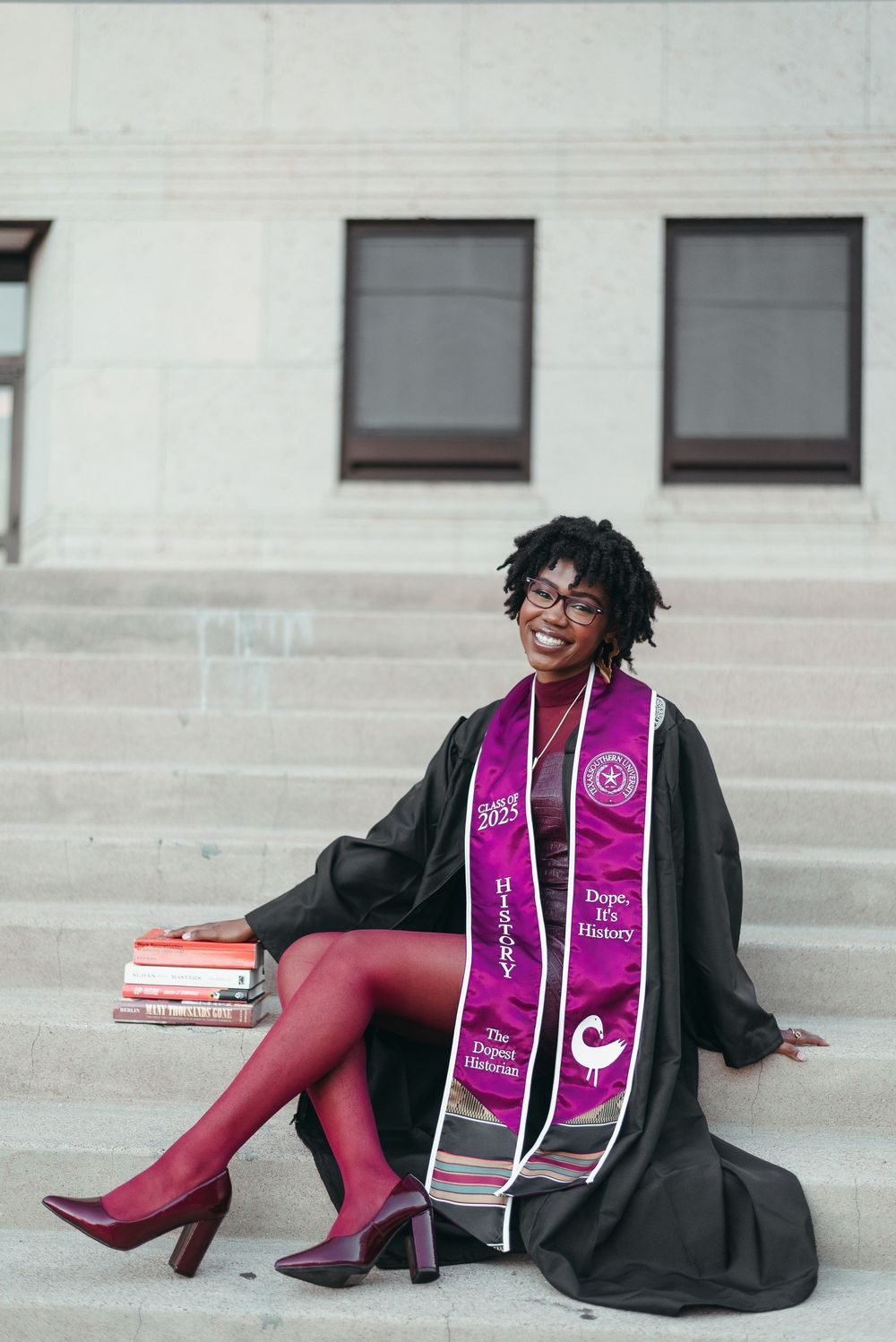 Graduate in black cap and gown with pink stole poses for creative collage photos on stone steps.