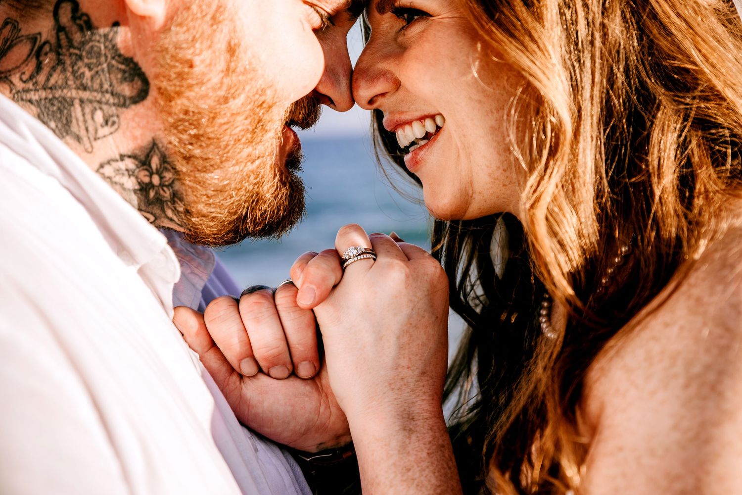 Close-up intimate portrait of couple sharing tender moment outdoors.