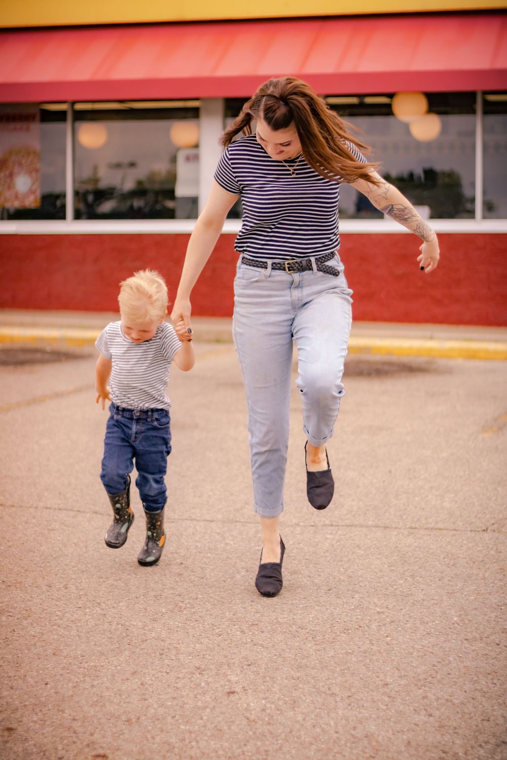 Close-up shot of legs walking together on concrete ground showing coordinated movement and matching steps between two people.