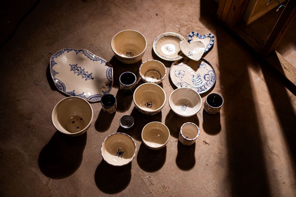 Overhead view of blue and white pottery collection arranged on a dark floor.