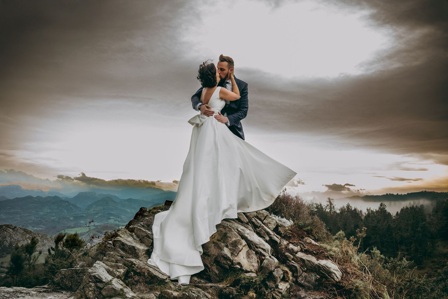 Pareja de novios abrazándose sobre una montaña en Asturias durante un reportaje de boda documental