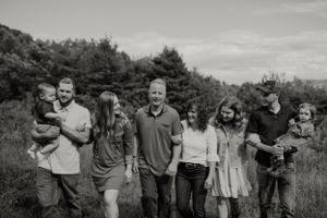 Group walking together through sunny meadow on casual outdoor outing.
