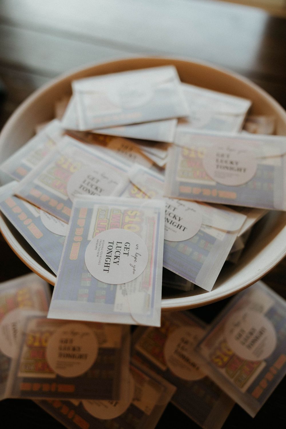 Bowl filled with lottery ticket wedding favors labeled get lucky tonight for guests.