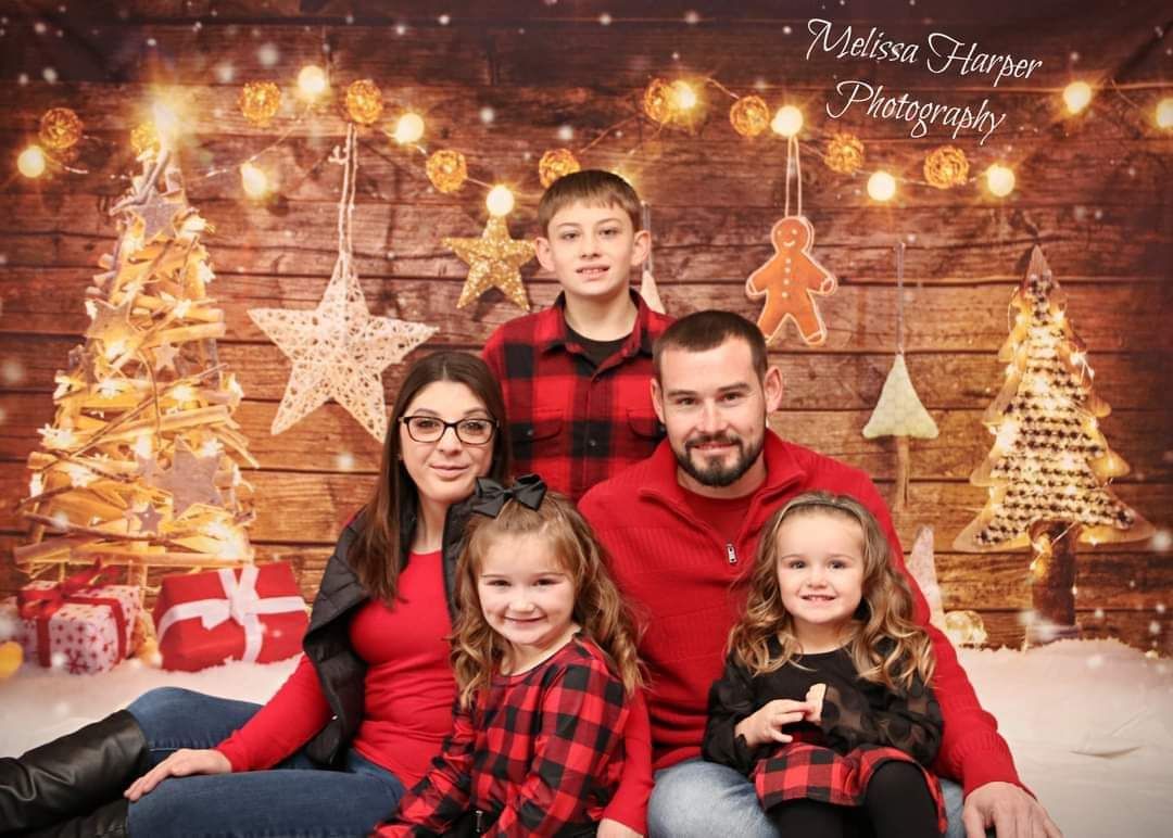 Christmas themed bedding setup with red plaid blankets, holiday pillows, and cookies with milk.
