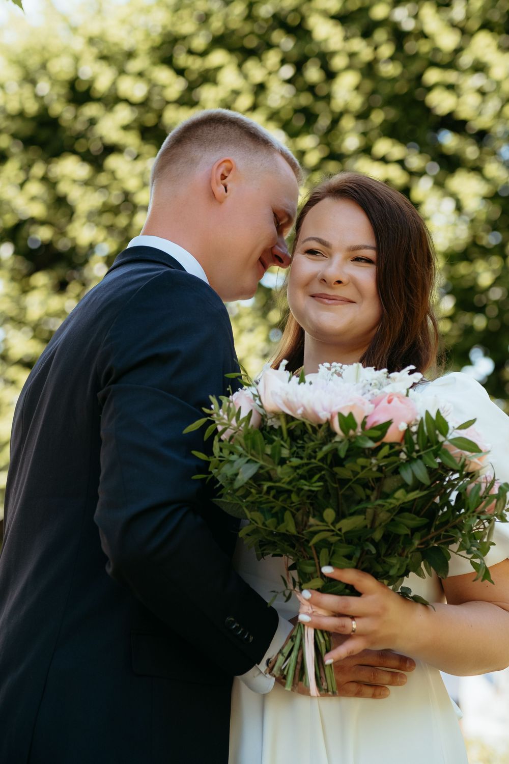 A romantic wedding moment captured in a series of five photos showing a couple embracing with a bouquet of flowers.