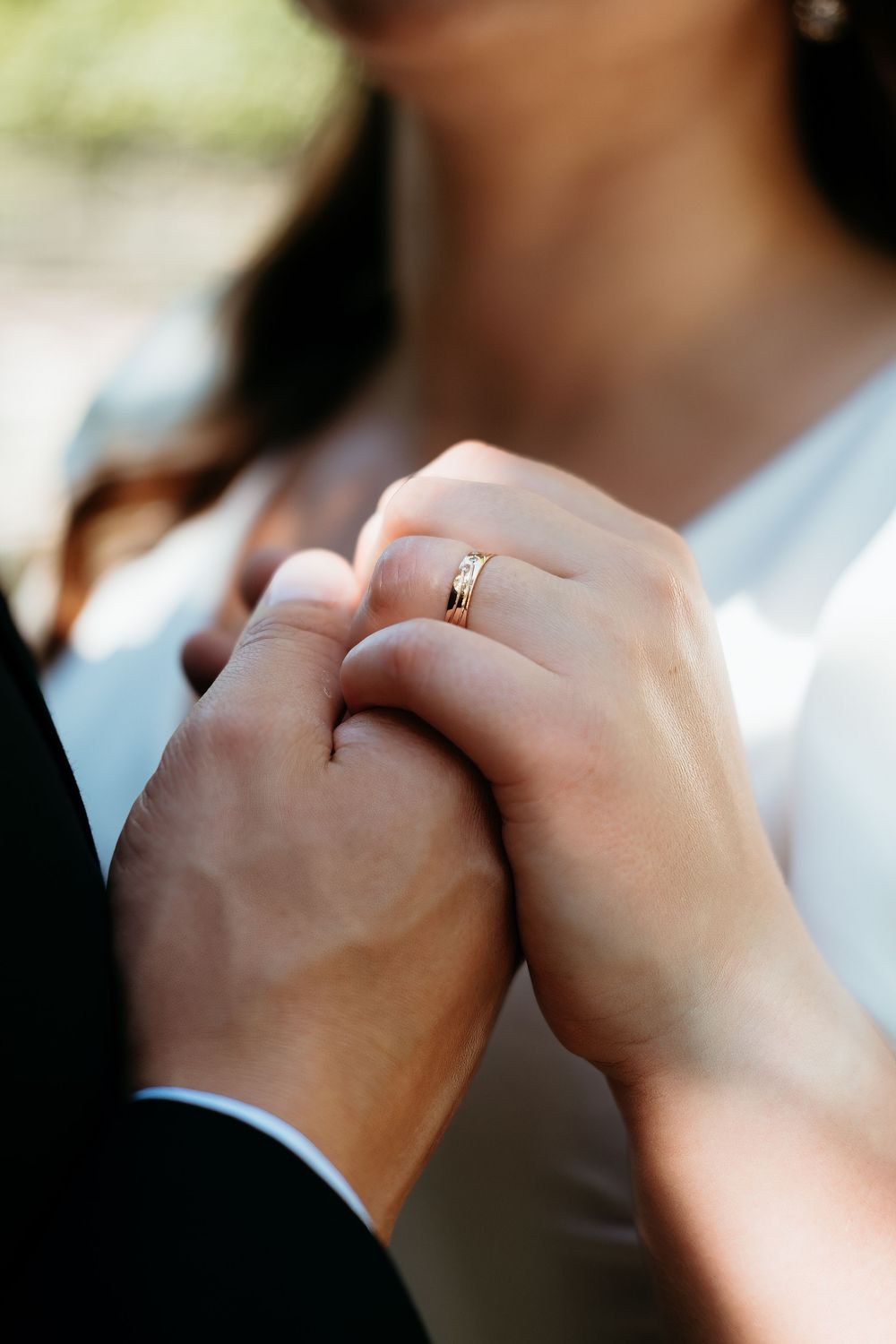 Close-up sequence of two hands clasped together showing wedding rings in soft natural lighting.