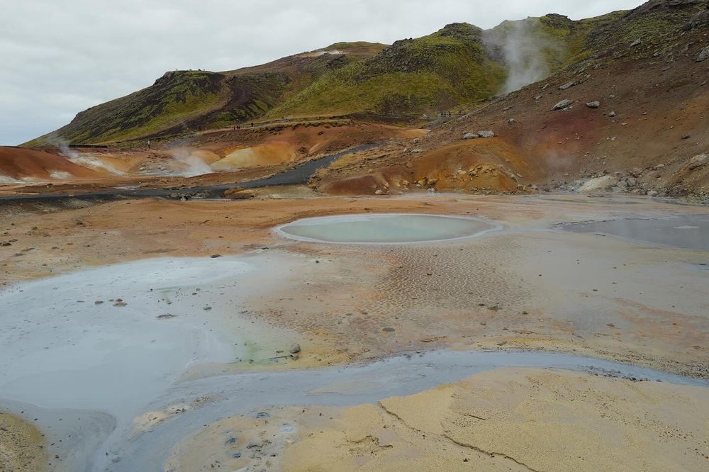Colorful geothermal landscape with steaming pools and mineral deposits in Iceland.