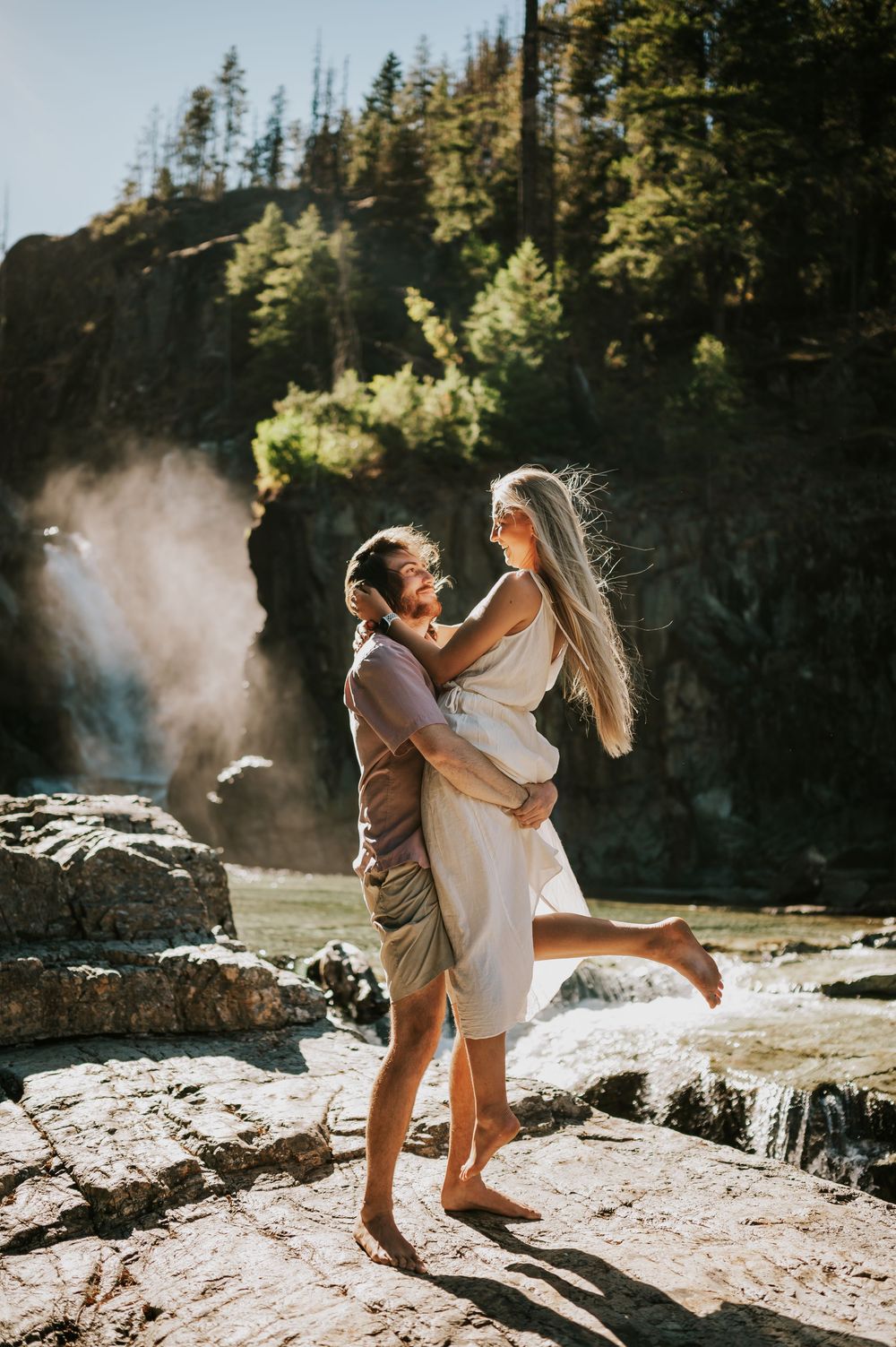 Couple adventure photoshoot session at Myra Falls on Vancouver island taken by professional photographer of couple spinning by waterfall