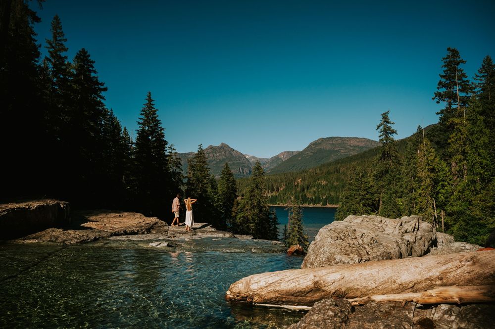 Couple adventure photoshoot session at Myra Falls on Vancouver island taken by professional photographer of couple gazing at mountain