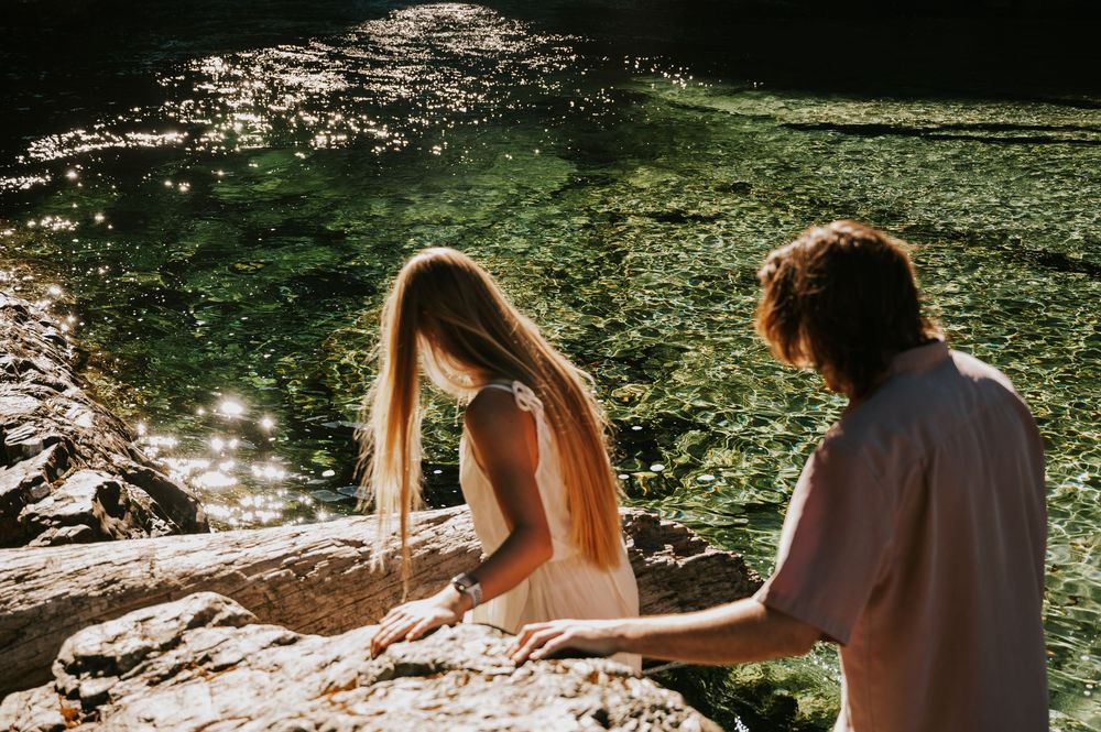 Couple adventure photoshoot session at Myra Falls on Vancouver island taken by professional photographer of couple walking by waterfall