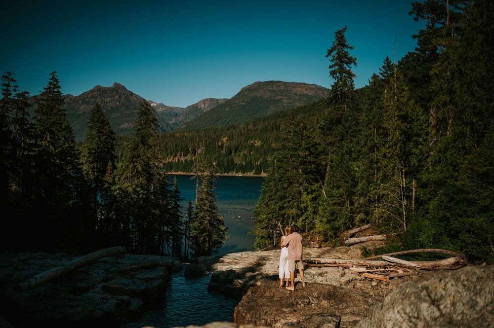 Couple adventure photoshoot session at Myra Falls on Vancouver island taken by professional photographer of couple looking at mountain