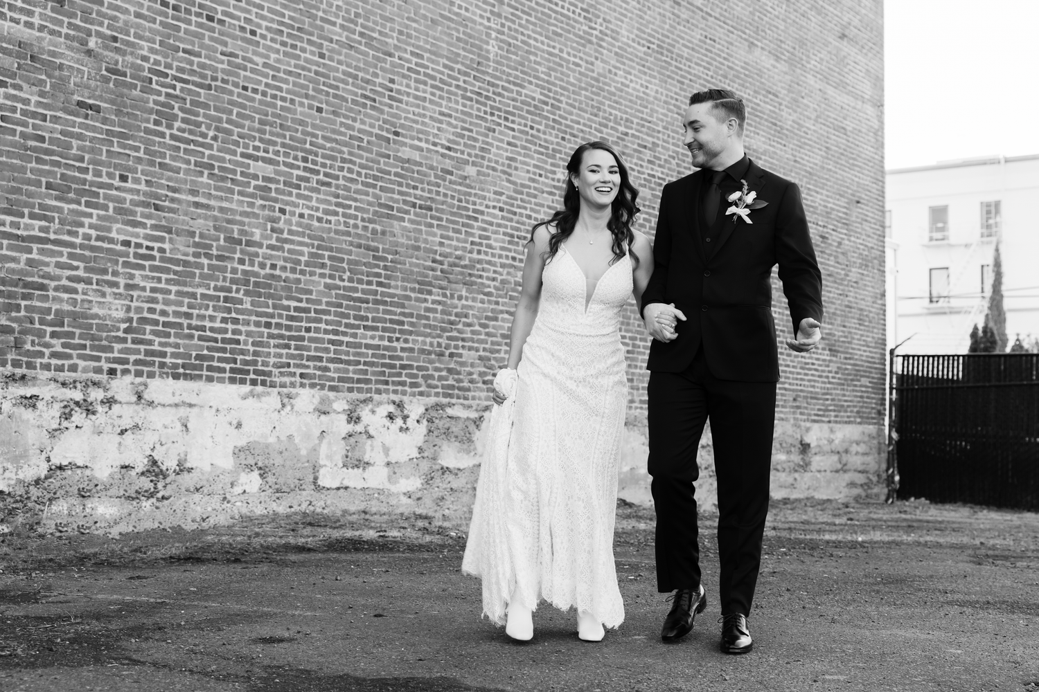 A wedding reception shows couples dancing in an industrial-style venue with exposed brick walls and large windows.