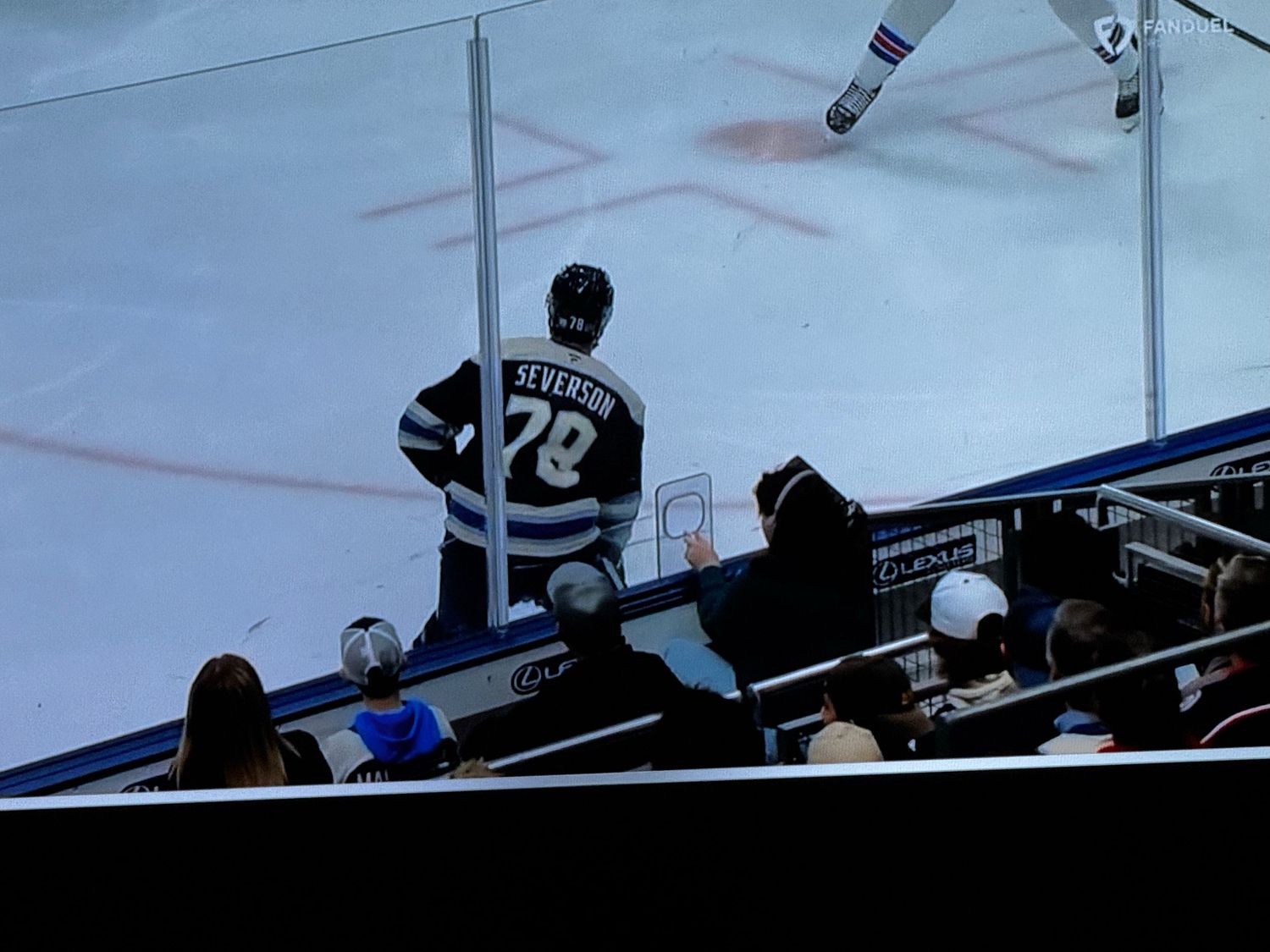 Hockey players and officials gather on the ice during an intense moment in a NHL game between the Rangers and Lightning.
