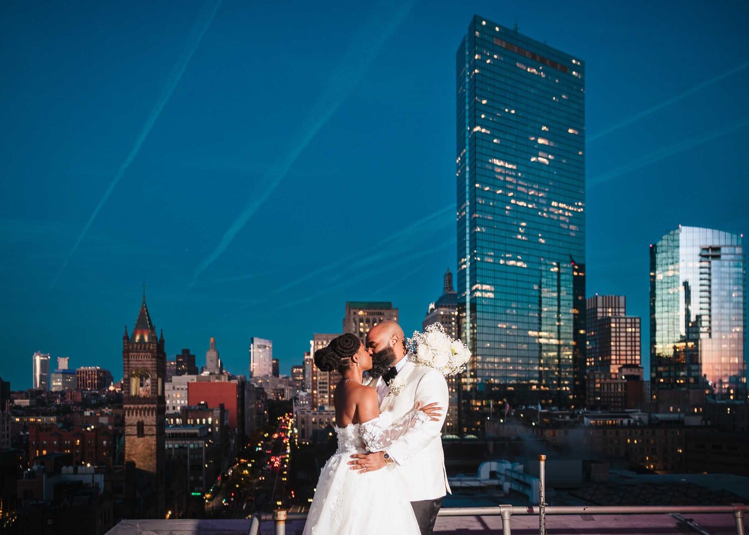 Bride and groom portrait at sunset overlooking Boston skyline on the rooftop deck at the Lenox Hotel Boston wedding photographer