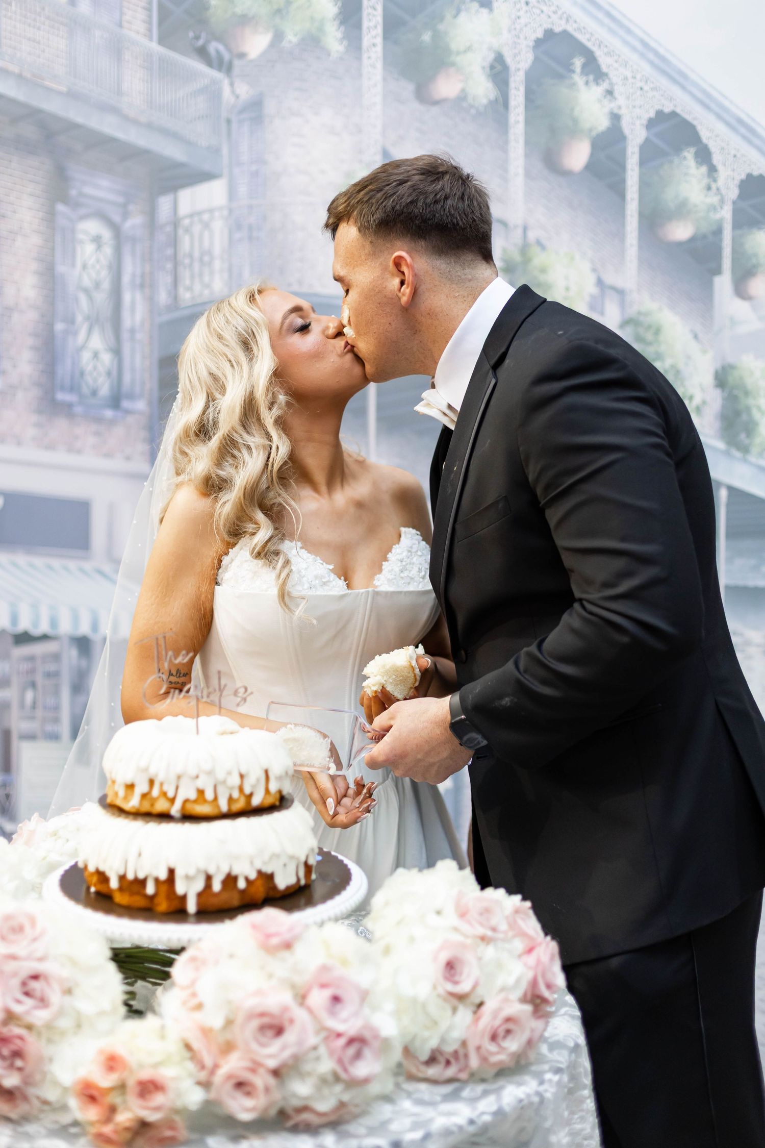 bride and groom kiss by cake
