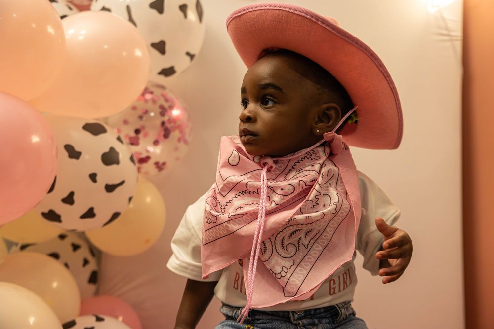 A pink and gold themed first birthday party celebration with balloons, decorations and festive party details.