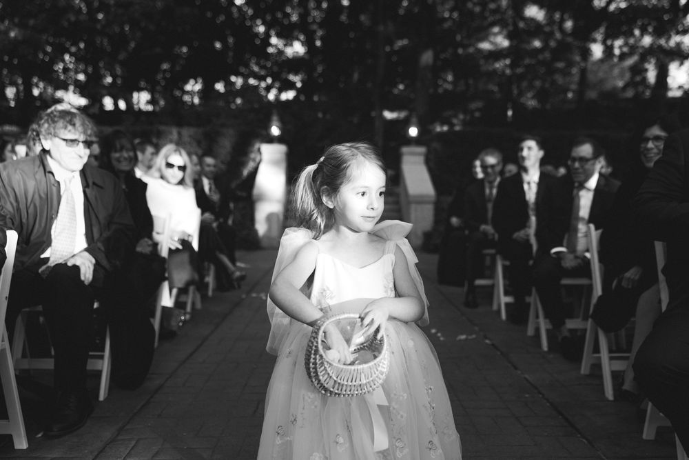 A couple dances together at an outdoor wedding reception while guests look on in the background.