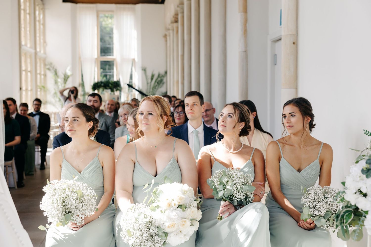 Panoramic collage of bridesmaids in light blue dresses holding white floral bouquets in an elegant white hallway.