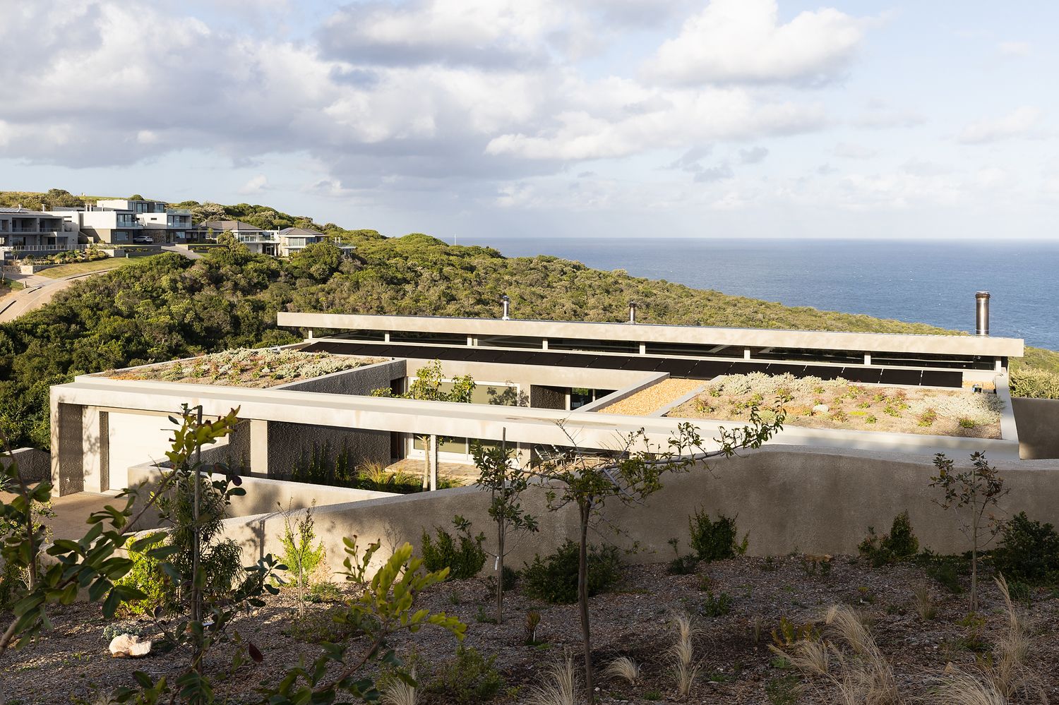 Ocean-facing terrace with minimalist outdoor furniture and uninterrupted sea views