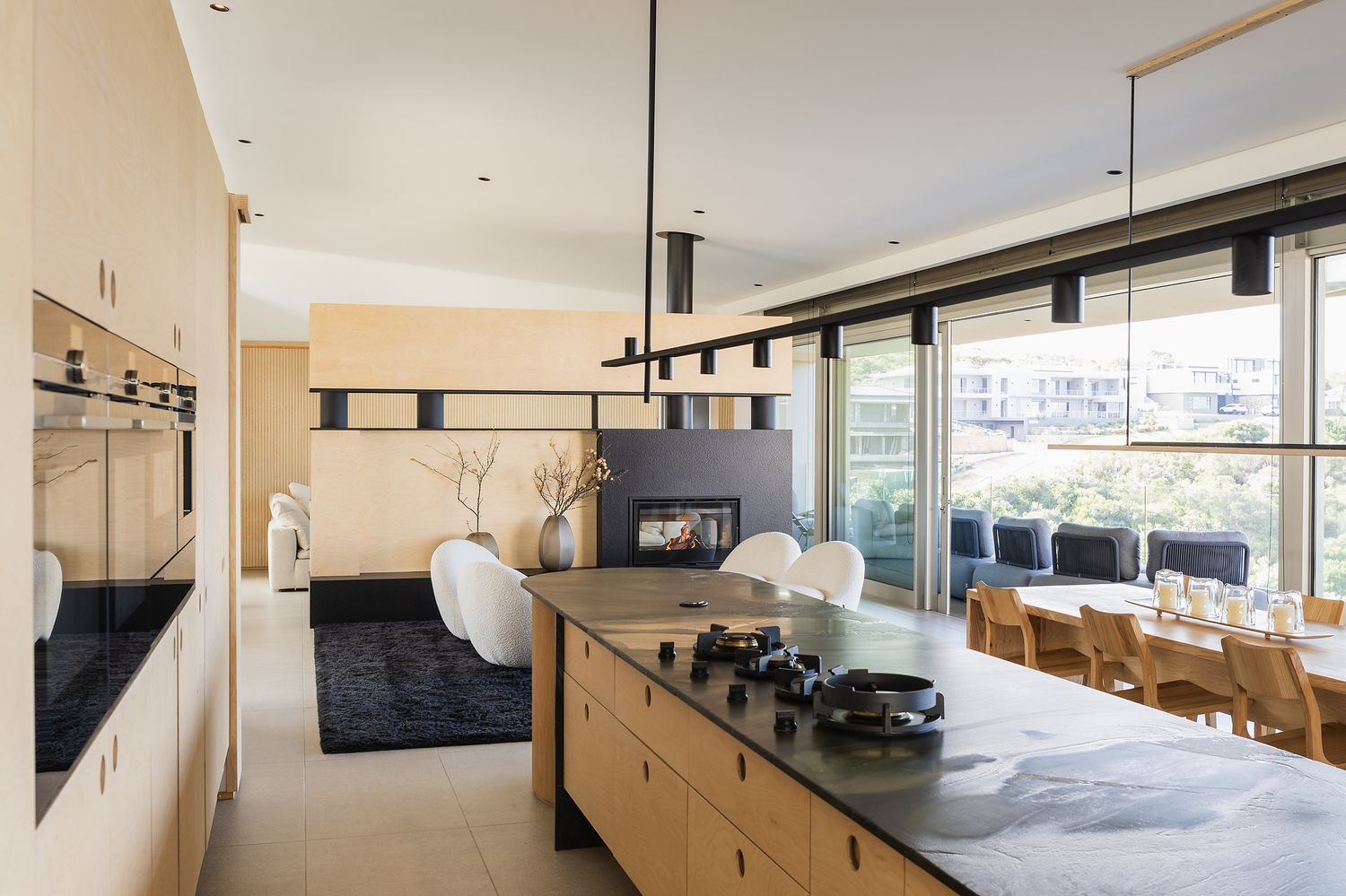 Open-plan lounge with soft furnishings, wooden accents, and relaxed coastal styling