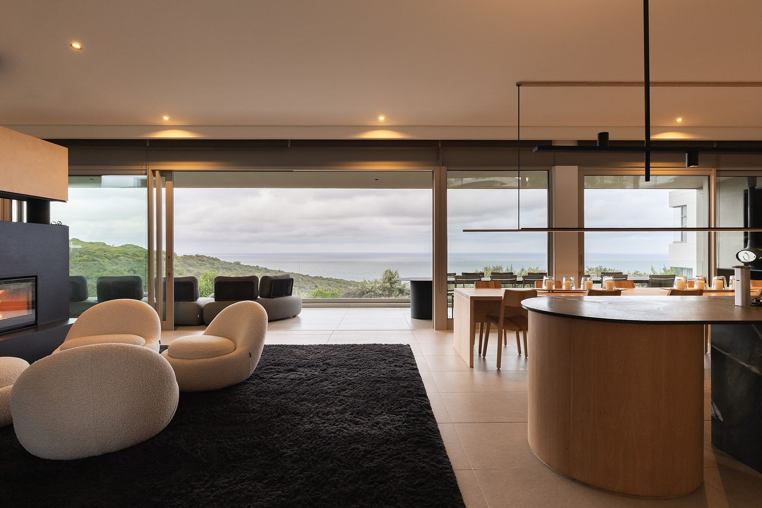 Warm modern living room with neutral textures, natural light, and ocean views