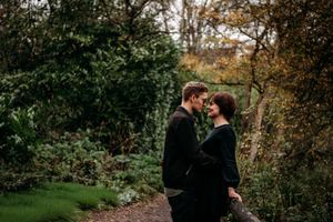 Silhouetted couple embracing in a lush garden setting during golden hour.