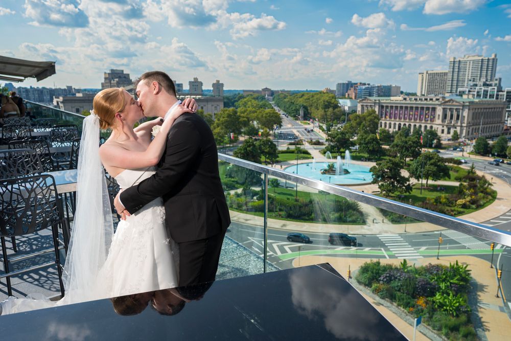 A panoramic collage of wedding photos showing outdoor venue views with city skylines and architectural details.