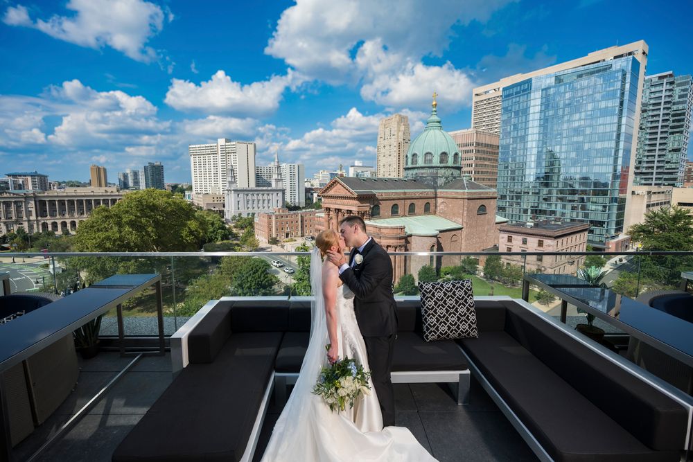 A rooftop terrace in downtown Chicago with modern glass buildings and blue skies visible in the background.