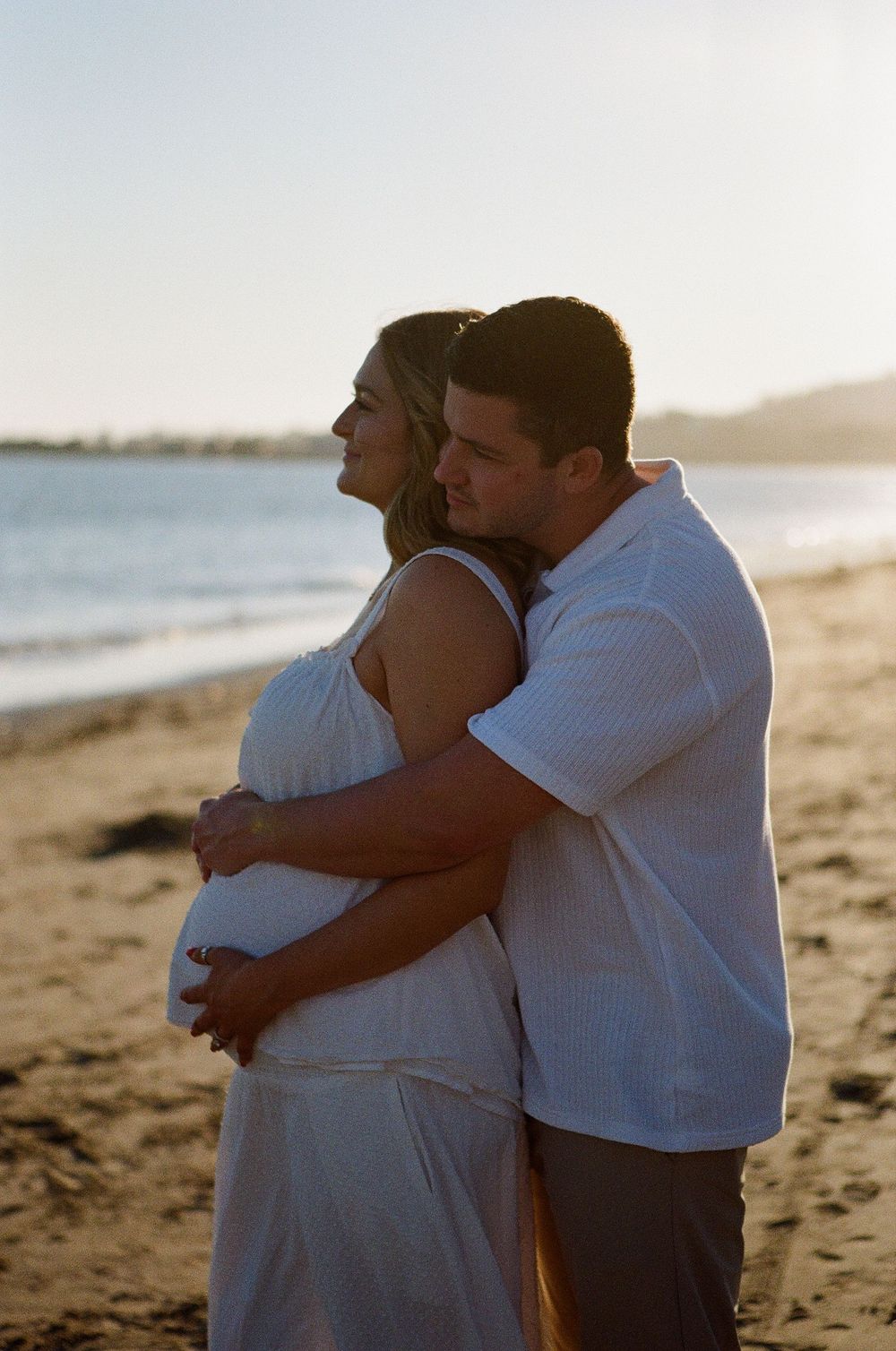 Wide-angle shot of a maternity session at a scenic Ventura County location, emphasizing the cinematic, hazy atmosphere unique to film.