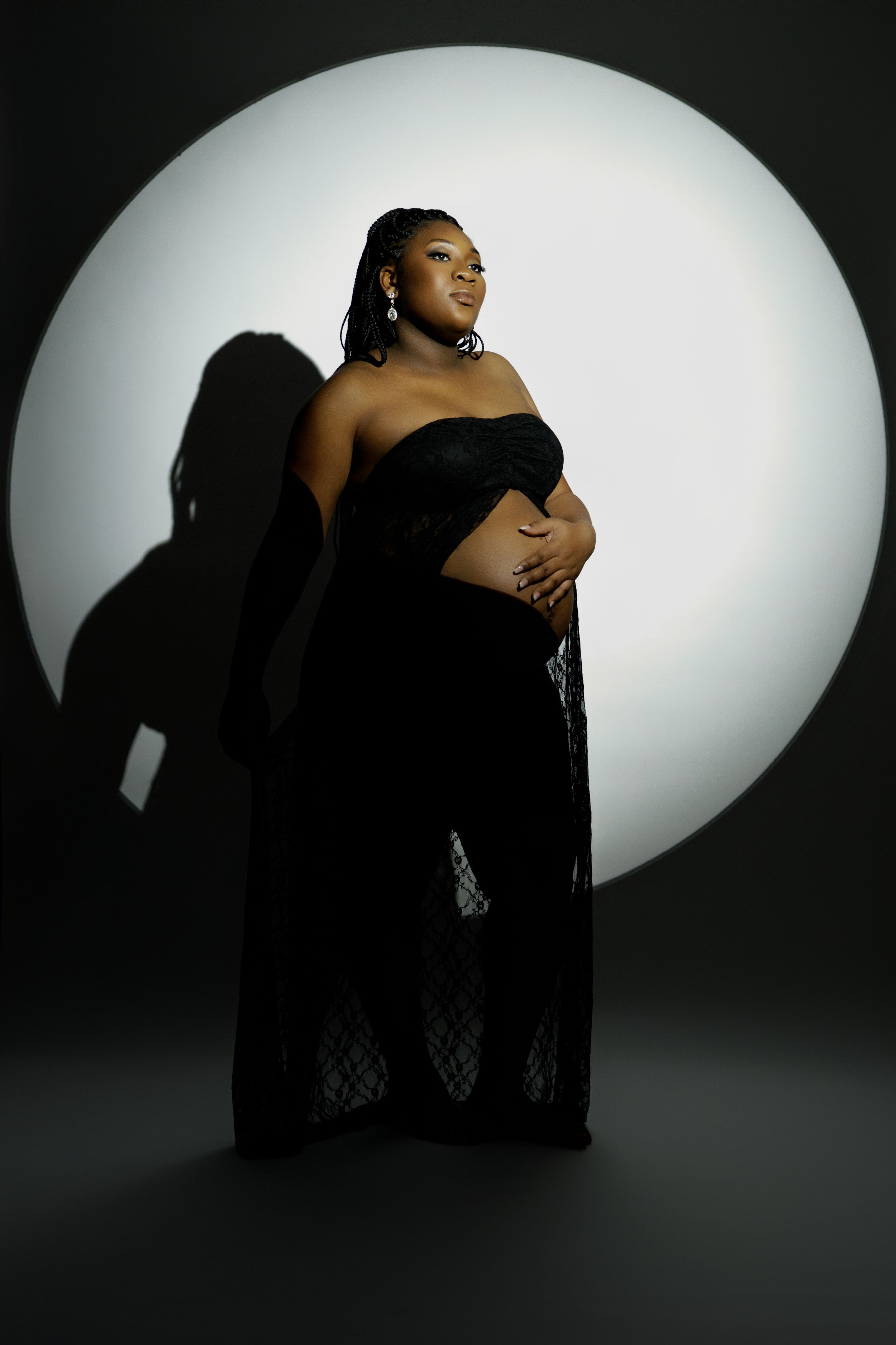 Artistic black and white silhouette photo series showing intimate poses against a glowing oval backdrop.