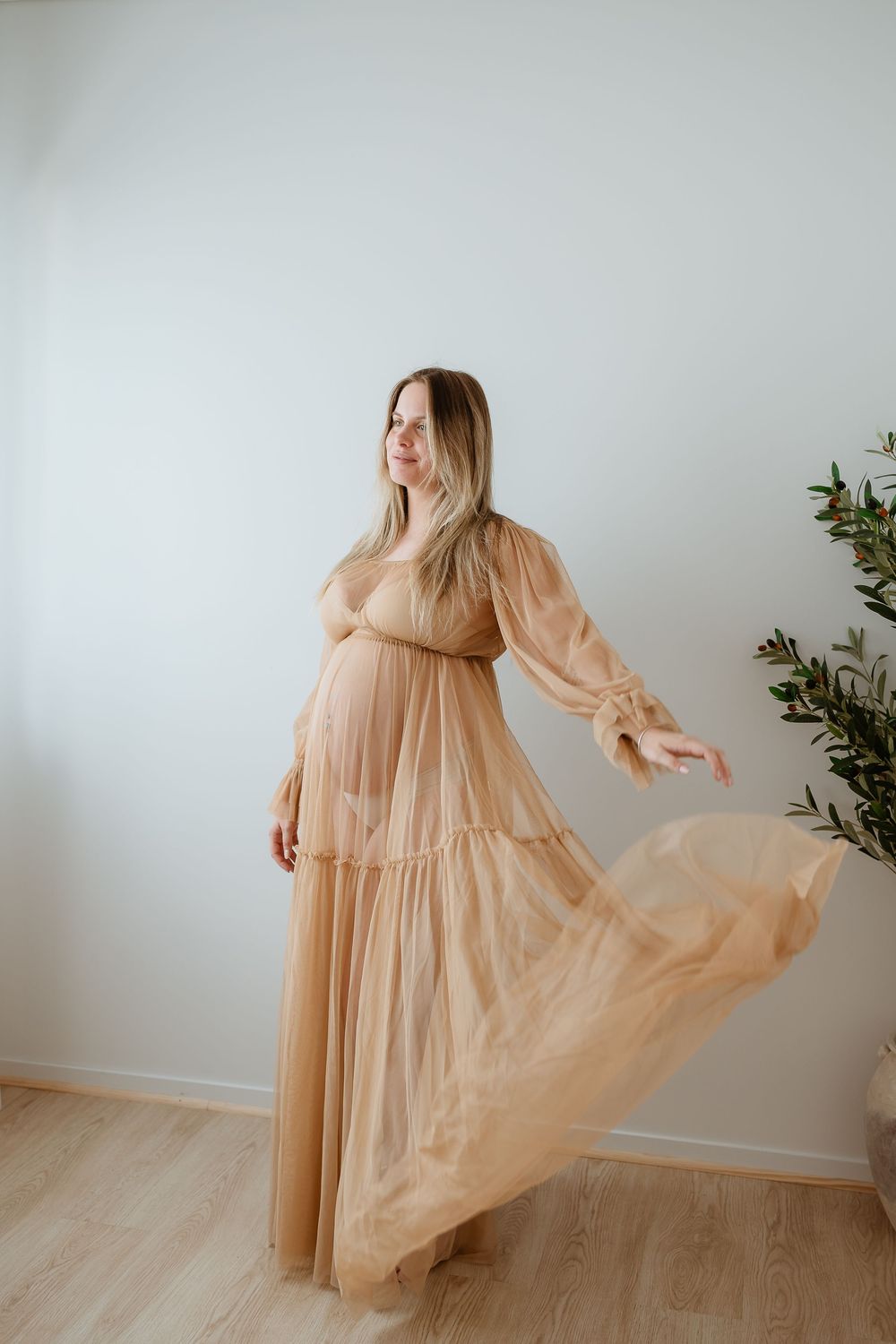 A flowing peach-colored sheer dress is captured in a series of ethereal movement shots against a minimalist white backdrop.