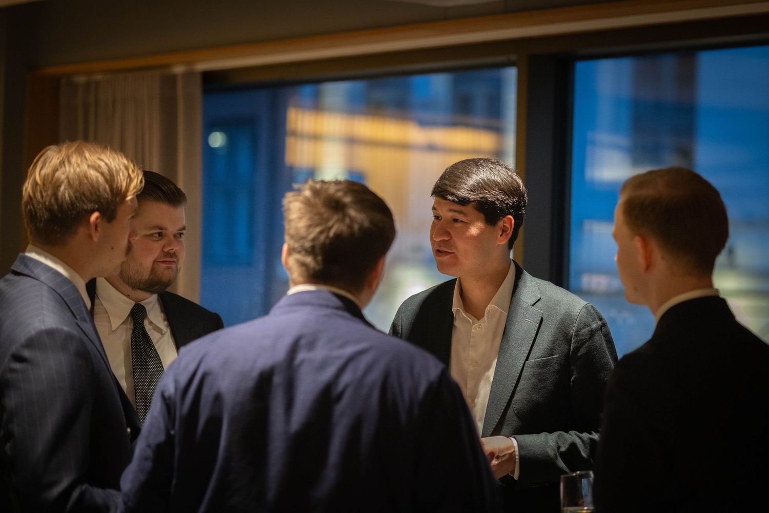 Gruppe mennesker i samtale ved vindu, bedriftsevent og nettverksfoto av Prospectxmedia.