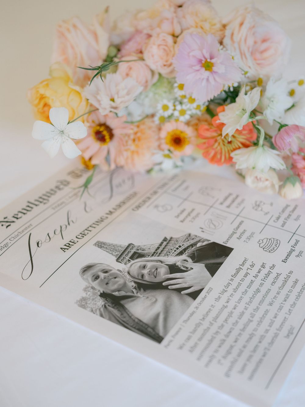 Wedding newspaper announcement with couple photo beside a colorful pastel bridal bouquet of roses and wildflowers.