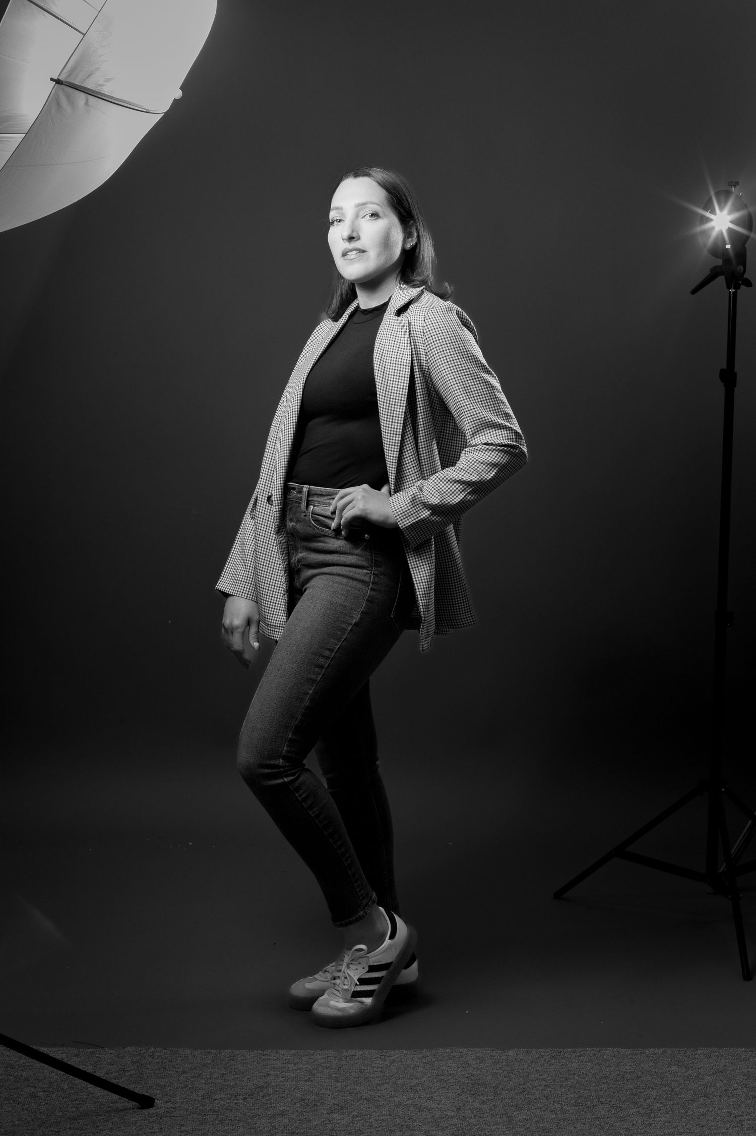 A series of black and white studio photographs showing a person in casual attire striking dynamic dance-like poses.