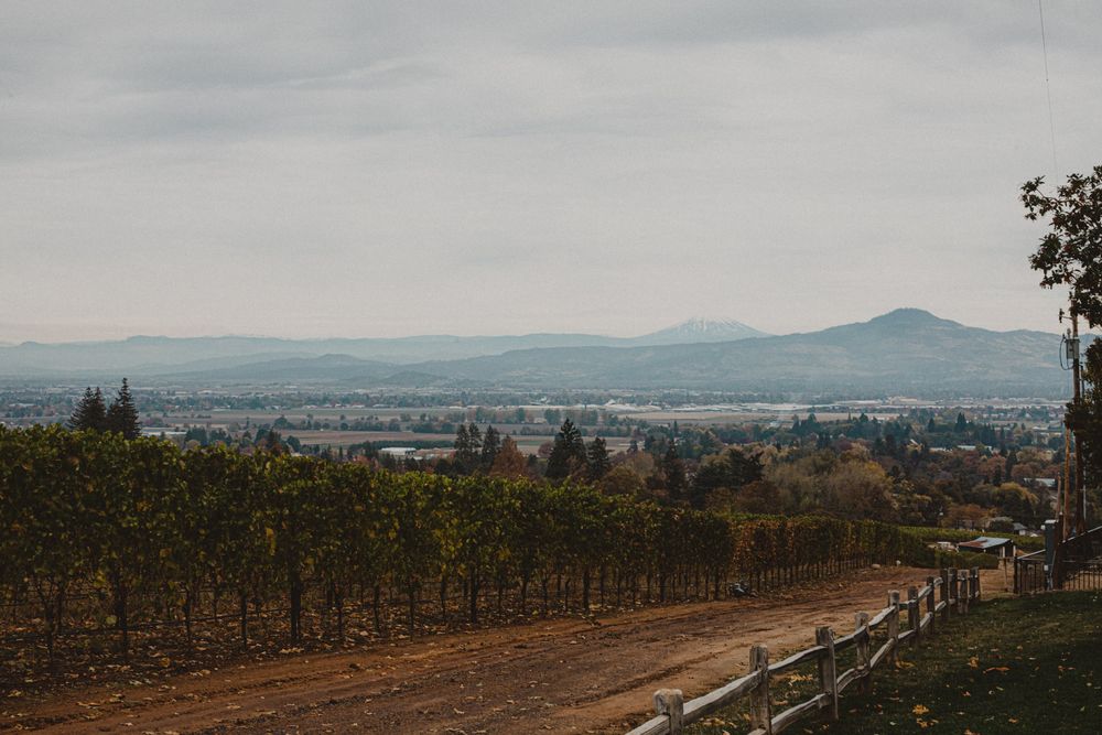 Panoramic cityscape view of Portland Oregon with mountains visible in the distant hazy horizon.