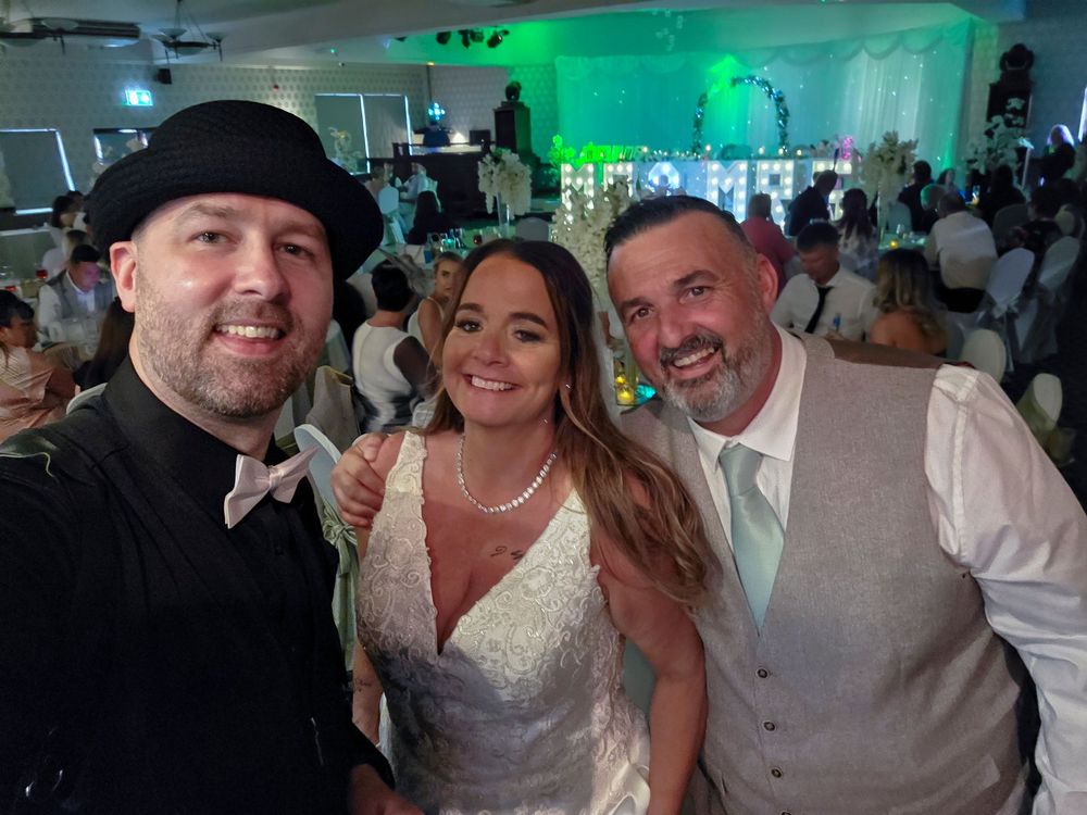 Wedding celebration in a venue with green lighting and festive atmosphere.