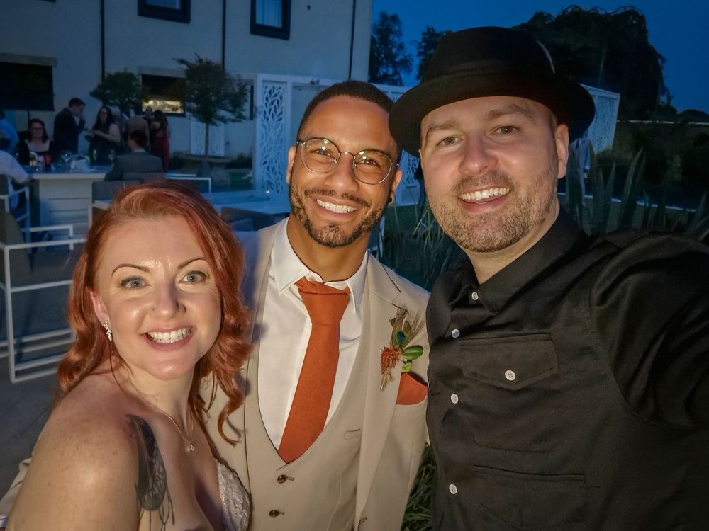 Evening outdoor wedding celebration with guests and photographers.