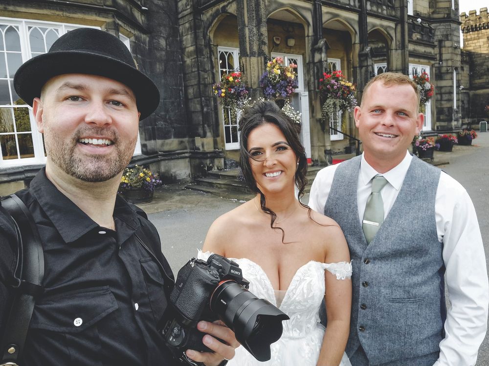 Outdoor wedding photography session in front of historic stone architecture.