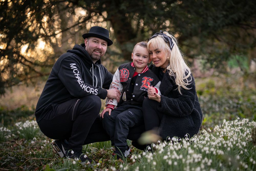 Family in matching black outfits poses among spring flowers.