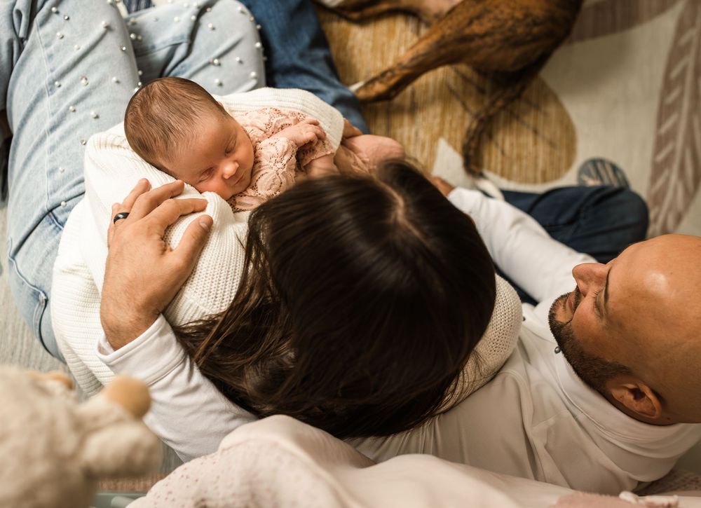 newborn photography at home session couple snuggling new baby