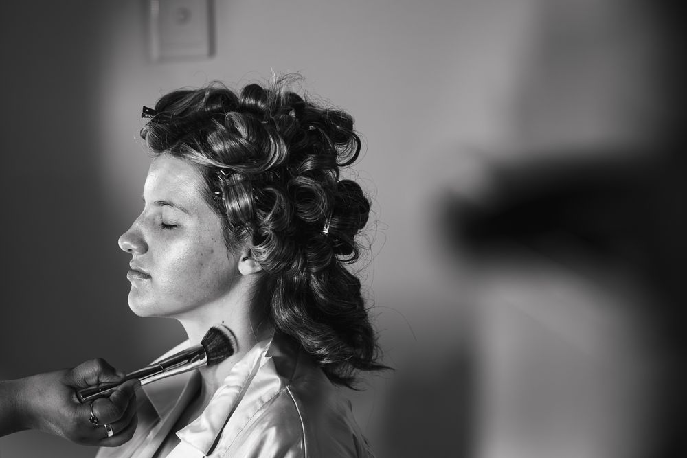 Black and white artistic and cinematic portrait of the bride getting her make up done taken by a Melbourne wedding photographer.