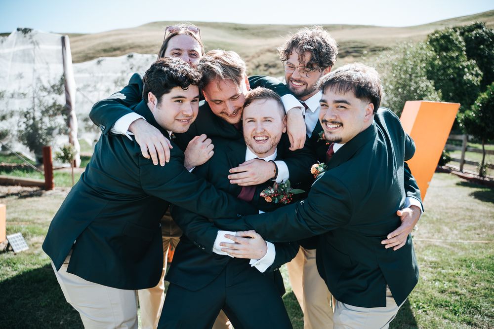 Groomsmen giving groom a big hug before the ceremony begins taken by a Melbourne wedding photographer.