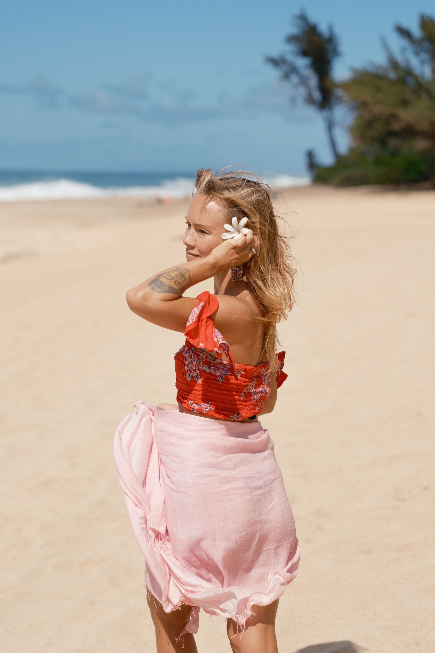 Woman posing on a tropical Oahu beach during a lifestyle portrait session with Hawaiian-inspired styling.