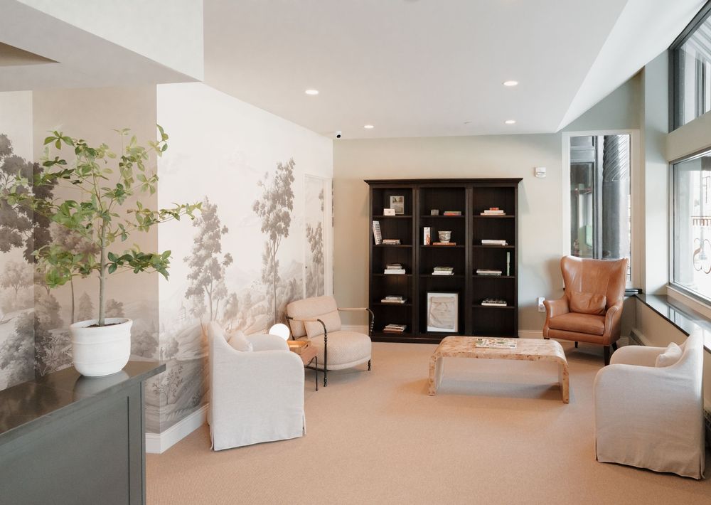 Bright modern medical waiting area with comfortable seating and nature-inspired wall murals.