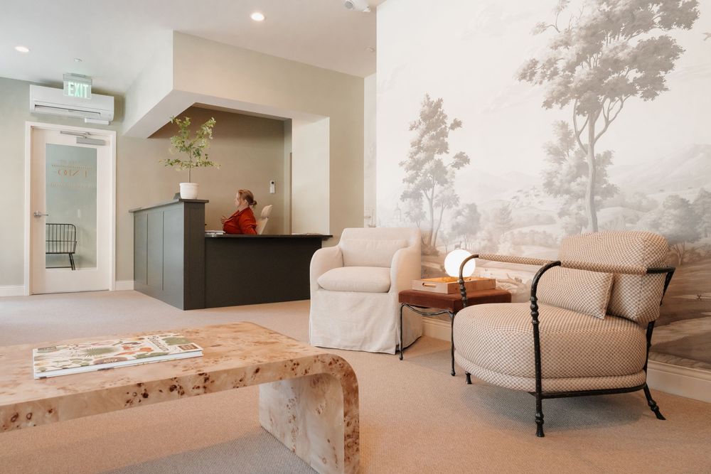 Contemporary medical office lounge featuring beige furniture and decorative wall art.